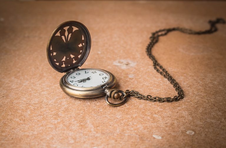 Antique Pocket Watch with Chain on Brown Surface